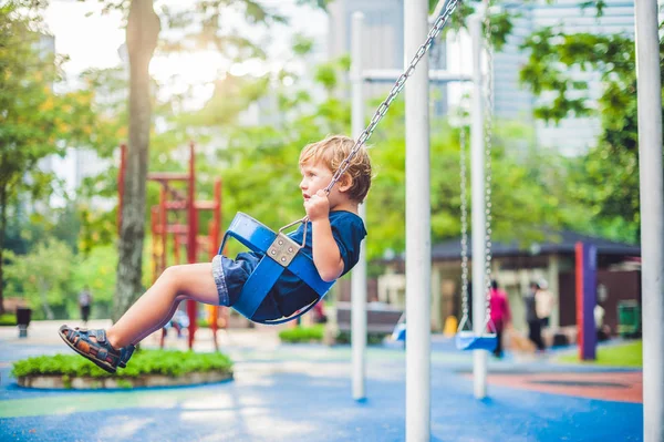 Little boy on a swing in the park. — Stock Photo, Image