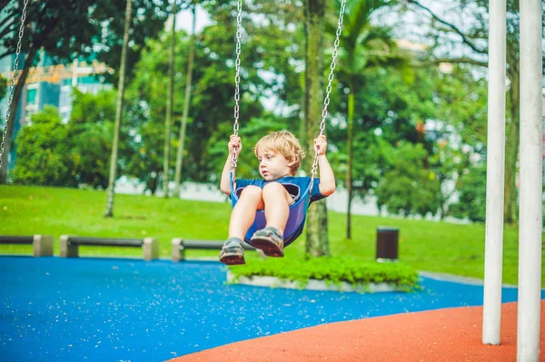 Kleiner Junge auf einer Schaukel im Park. — Stockfoto