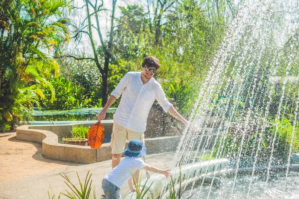 Father and son playing at the fountain — Stock Photo, Image