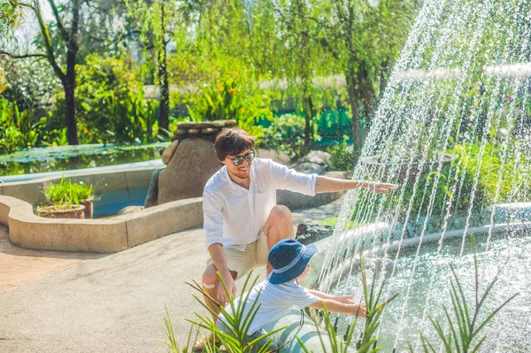 Father and son playing at the fountain — Stock Photo, Image