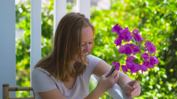 Junge Frau mit lila Blüten im Frühling — Stockvideo