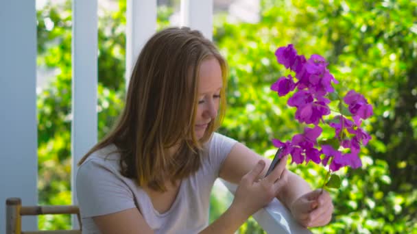 Ung kvinna med lila vårblommor — Stockvideo