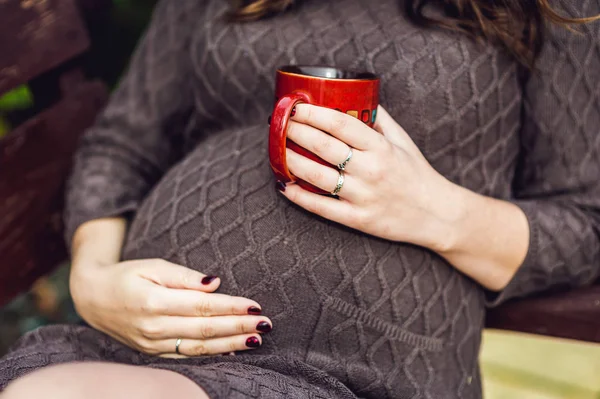 Bauch einer schwangeren Frau mit Tee — Stockfoto