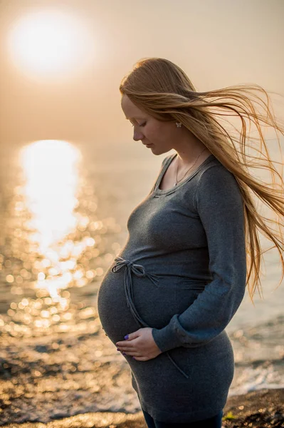 Mulher grávida de pé na praia — Fotografia de Stock
