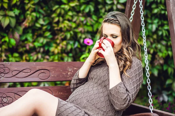 Jeune femme enceinte avec une tasse de thé — Photo