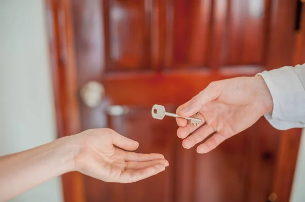 Die Hand des Mannes gibt eine weibliche Schlüsselhand — Stockfoto