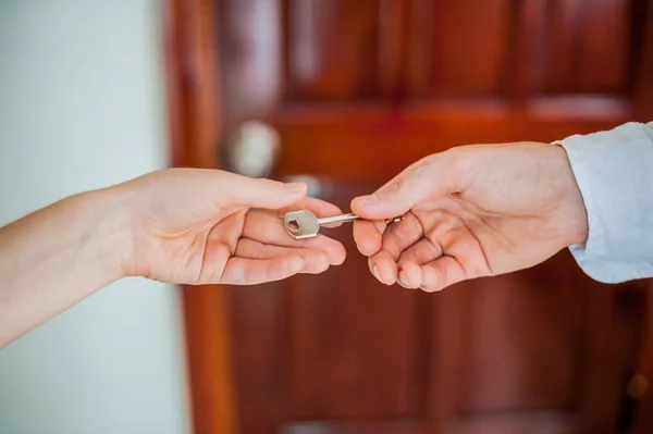 Die Hand des Mannes gibt eine weibliche Schlüsselhand — Stockfoto