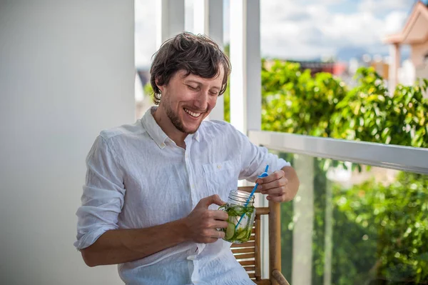 Человек пьет мохито на террасе . — стоковое фото