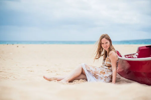 Young girl sits on the beach — Stock Photo, Image