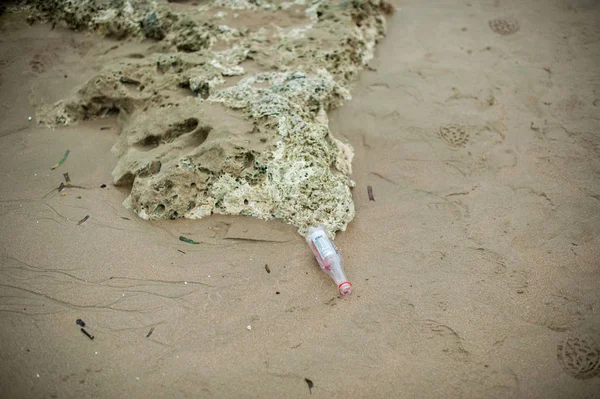 Garrafa de lixo vazia na praia de areia — Fotografia de Stock