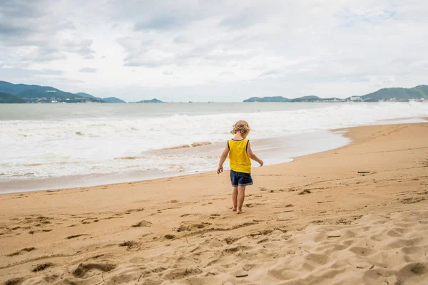 Маленький мальчик на пляже в плохую погоду . — стоковое фото