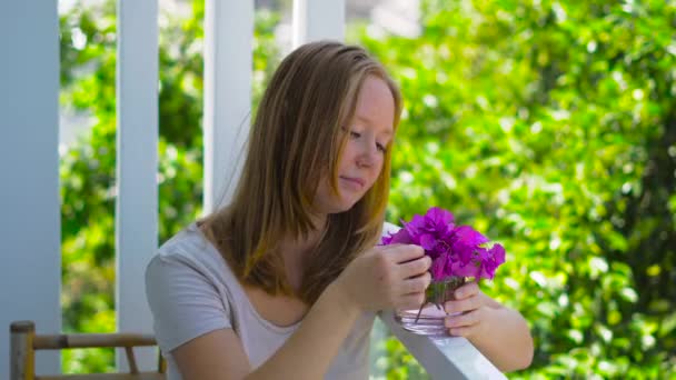 Ung kvinna med lila vårblommor — Stockvideo