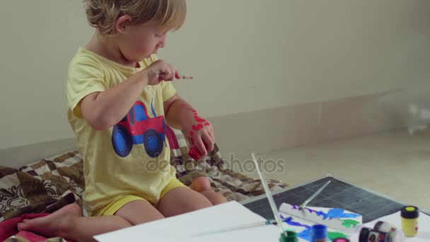 Menino brincando com pintura em suas mãos — Vídeo de Stock