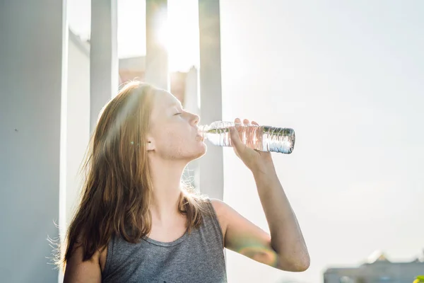 Mujer joven está bebiendo agua — Foto de Stock