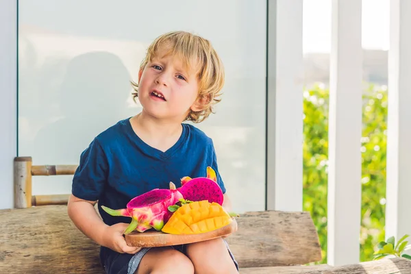 Niño con fruta de dragón y mango — Foto de Stock