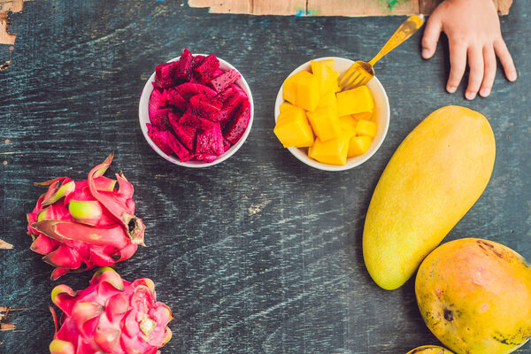 Маленький милый мальчик ест манго
