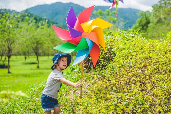 Jongetje en een pinwheel windmolen — Stockfoto