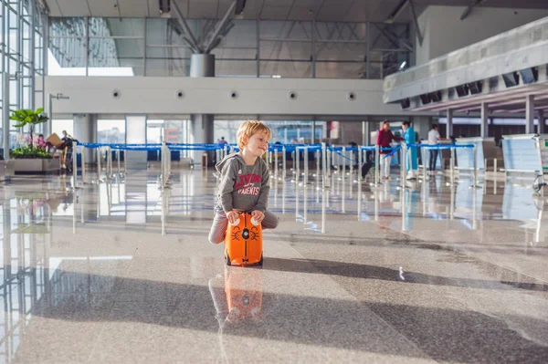 Netter kleiner Junge mit orangefarbenem Koffer — Stockfoto