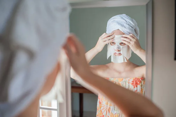 Mujer haciendo mascarilla facial hoja —  Fotos de Stock