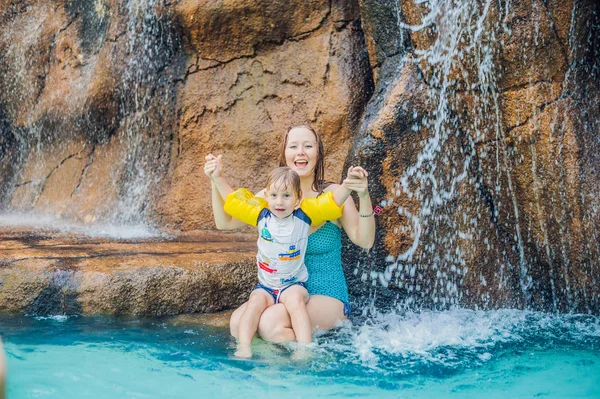 Mãe e filho relaxando sob uma cachoeira — Fotografia de Stock
