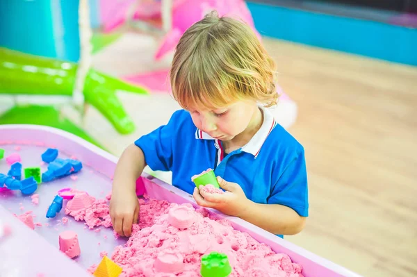 Junge spielt mit kinetischem Sand — Stockfoto