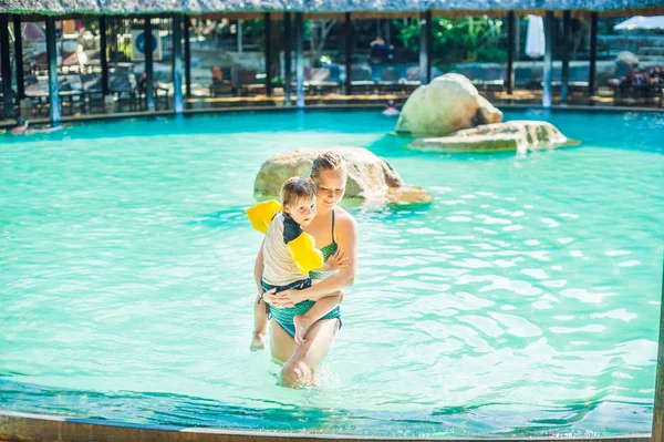 Moeder en todler zoon in een zwembad. — Stockfoto