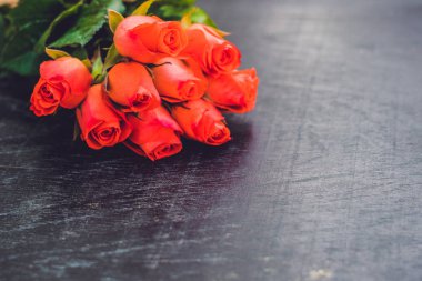 Eski ahşap bir masada kırmızı güller