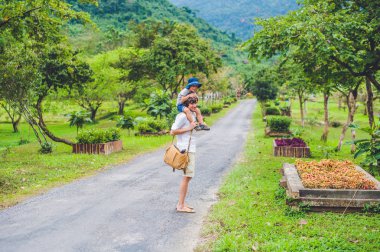Baba ve oğul manzaralı bir yolda yürürken