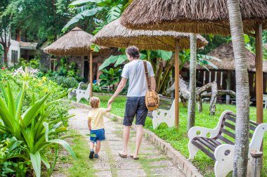 Baba ile oğlu yolda bir parkta yürüyüş