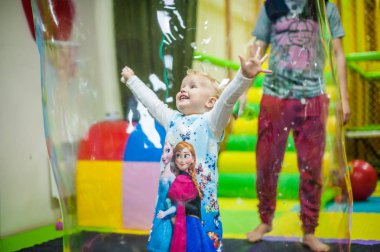 Kız Festivali sabun köpüğü arasında duruyor. Çocuk tatil kavramı