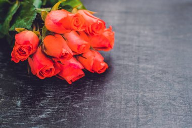 Eski ahşap bir masada kırmızı güller