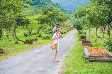 Baba ve oğul manzaralı bir yolda yürürken