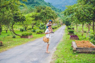 Baba ve oğul manzaralı bir yolda yürürken