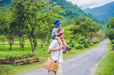 Baba ve oğul manzaralı bir yolda yürürken