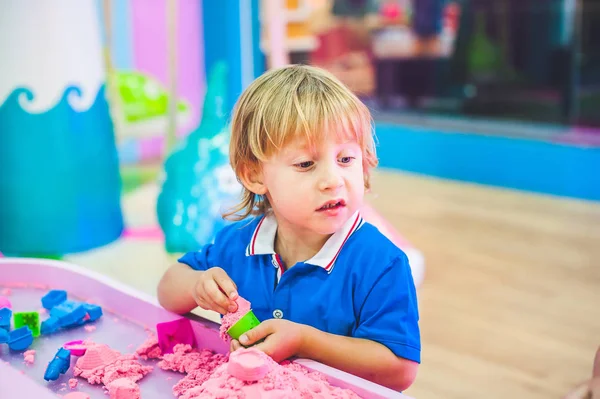 Menino brincando com areia cinética — Fotografia de Stock