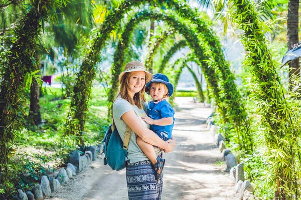 Madre e figlio in un giardino tropicale — Foto Stock