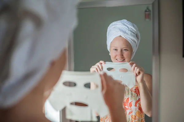 Mujer haciendo mascarilla facial hoja — Foto de Stock