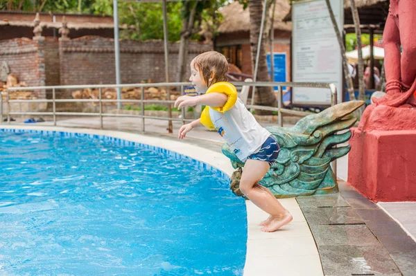 Jongen springen in het water van het zwembad. — Stockfoto