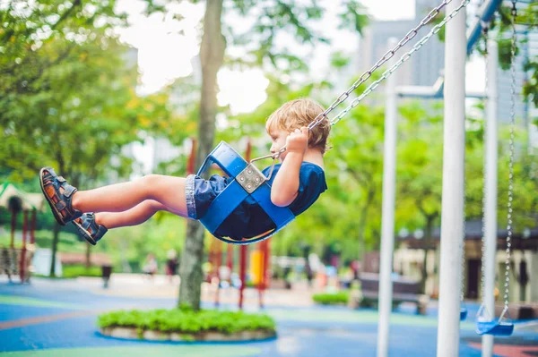Little boy on a swing in the park. — Stock Photo, Image