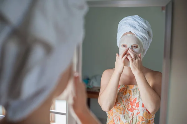 Mujer haciendo mascarilla facial hoja —  Fotos de Stock