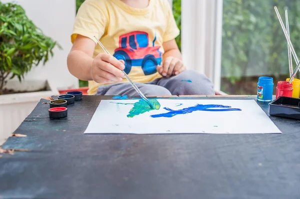 Kleiner Junge malt mit bunten Farben — Stockfoto