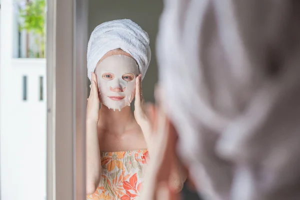 Femme faisant la feuille de masque facial — Photo