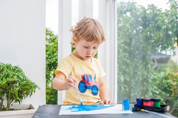 Kleiner Junge malt mit bunten Farben — Stockfoto