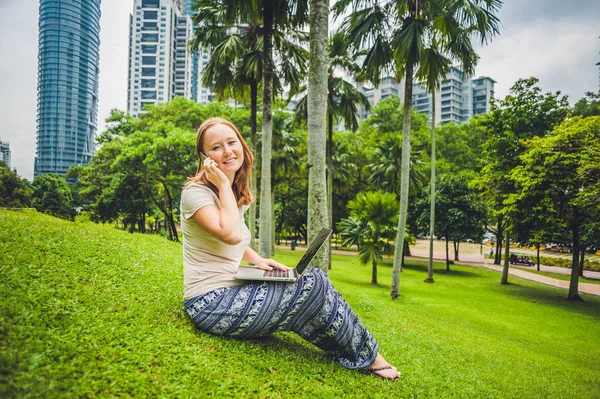 Junge Frau in lässigem Kleid mit Laptop — Stockfoto