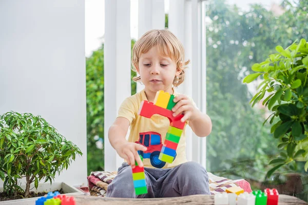 Menino com blocos de plástico coloridos — Fotografia de Stock