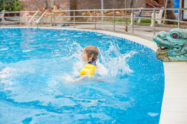 Garçon sauter dans l'eau de la piscine . — Photo