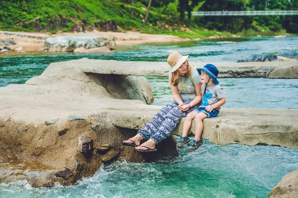 Matka a mladý syn sedí na mostě — Stock fotografie