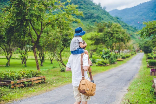 Baba ve oğul manzaralı bir yolda yürürken