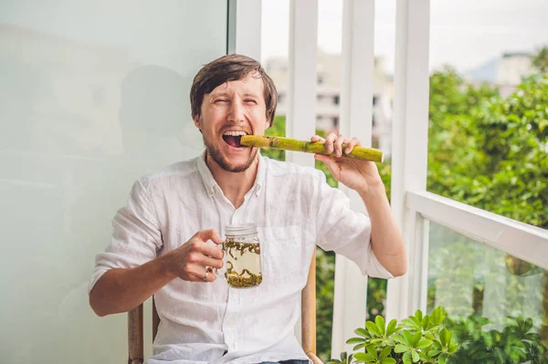 Man jokingly eating sugar cane — Stock Photo, Image