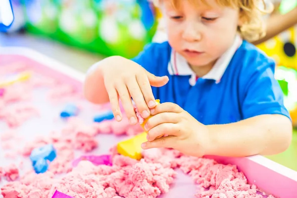 Junge spielt mit kinetischem Sand — Stockfoto